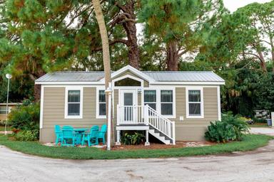 Exterior photo of a rental cabin on-site — shows cabin style and outdoor seating, matching the Cabin page content.