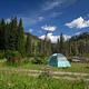 A blue sky and green hills form a backdrop for Slough Creek Campsite #7