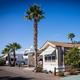 Close view of annual/long-term RV/park model sites with palms and paved pads — useful to show site types available at the resort.