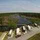Aerial view showing RV sites along the waterfront, marina/boat area and surrounding wetlands — good overall overview of property layout (homepage waterfront image).