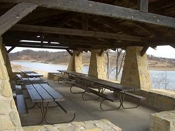 A view under the of the pavilion showing 4 picnic tables