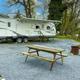 RV/trailer seasonal site with gravel pad, picnic table and fire ring — useful depiction of a typical seasonal/RV campsite on the property (matches ‘seasonal sites’ page context).