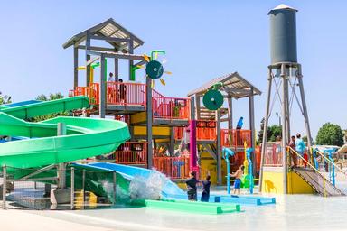 Colorful children’s water play structure and slides — highlights the on-site splash/play attraction for families, taken from the property’s official site.
