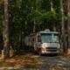 Large RV parked in a wooded pull-through site — demonstrates the campground's RV accommodation and tree-lined sites.