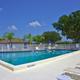 Alternate pool perspective with seating and umbrellas, giving detail of pool area and adjacent facilities — complementary amenity image (photos gallery).
