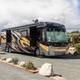 Clear photo of a large motorhome parked on a paved RV pad with picnic table and landscaping — shows the RV sites and pad layout on the Palm Springs KOA property (sourced from the campground waystostay photos page).