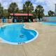 Panoramic/ground-level photo of the two pools and pool deck with chairs — good close-up of primary guest amenity and seating areas (matches site pool images).