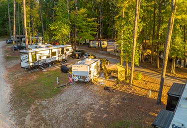 Elevated shot of multiple RV sites among tall pines, giving a sense of campsite layout and spacing — useful for prospective guests. Included in the resort’s gallery on the property page (page: Lake Gaston RV Camping | Thousand Trails RV Campground, URL provided).