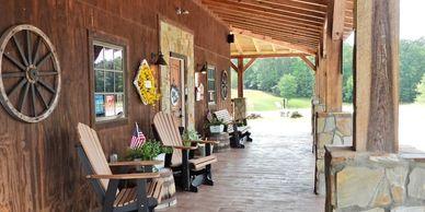 Covered porch seating and cabin/office exterior area with decorative elements — highlights communal building and guest seating area (Amenities page).