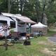 Detailed campsite / RV pitch showing an occupied RV, awning and site furnishings — good representation of typical RV sites and guest setup from the gallery.