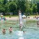Lakeside scene with swimmers and a water slide/dock at the beach — shows on-site waterfront recreation and beach area (from Campground events / Lake Days gallery).