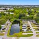 Aerial overview showing the campground layout with central pond, RV sites and roads — good overall property view. Matches gallery page context (Aerial View of Property).