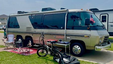 On-site RV campsite shot showing an RV parked on a concrete pad with site furnishings and nearby sites visible — illustrates typical RV accommodations at the park (from site image set).