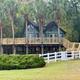 Distinct elevated cabin/house on stilts with surrounding grounds and palms — useful scenic lodging shot. Source is the property's stay page, indicating it's on‑site accommodation.
