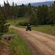 Individual riding an ATV on a dirt road.