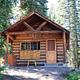 The front of a wooden cabin in a forest