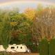 Panoramic shot across campground showing RVs and sites with a rainbow and trees — good overall view of RV pitches and grounds (from homepage slideshow at https://www.tippicanoe.com/).