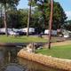 View of the RV pitches along the water with site landscaping and seawall — good depiction of the park’s RV area and shoreline (from the site’s gallery).