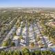 High-altitude aerial view showing the full resort layout with neat rows of RV sites, drive aisles, surrounding neighborhood and nearby SeaWorld skyline visible — confirms property-scale overview on the Admiralty RV Resort page.
