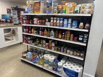 A well-stocked convenience store shelf with groceries and toiletries.