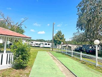 Shuffleboard courts with RVs and parking visible — highlights recreational amenity and nearby RV sites on the property.