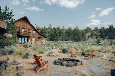 Cabin/lodge exterior with a firepit seating area and natural landscape — shows guest accommodation and communal outdoor space on the property (appears on the property's main gallery).