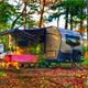 Clear photo of an RV at a campsite with picnic table and wooded setting—good representation of individual RV/tent sites on the property (found on the park’s homepage gallery).