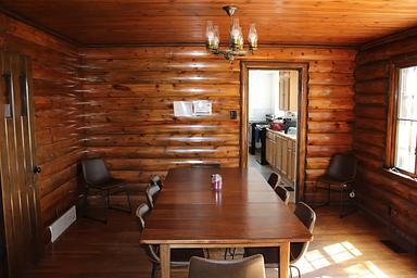 Redfeather Ranger Cabin dining room showing table with eight chairs, and chandelier.