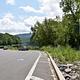 Boat Ramp with two vehicles and Disabled parking sign with mountain in distance.
