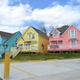 Row of colorful waterfront cottages shown from ground level — useful to show cabin/accommodation options on the property (from the site’s About page).