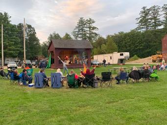 Outdoor stage with audience seated on campground lawn — documents on-site entertainment and common area (homepage slideshow at https://www.tippicanoe.com/).