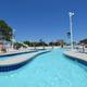 Ground-level view of the water park’s lazy river and play features, showing slides, pools and deck seating — useful detail of a major on-site amenity. Page context labels this as Sandy Harbor Water Park.