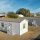 Aerial/campus-style view of manufactured homes/cabins within the park and paved roads — useful to show alternate lodging options and site arrangement (homepage image file named 'houses').