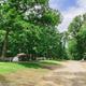 Scenic campsite/tent area with a tent, tree-lined sites and campground road — useful for showing tent camping and wooded character of the Brown County KOA. Sourced from the property 'ways to stay' images on the KOA page.