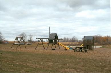 Playground and picnic area photo showing on-site family amenities and open space; image appears in the campground’s photo gallery (playground scene).