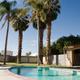 On-site swimming pool with palm trees and fencing visible; labeled on the site’s Amenities/Activities page, useful to show park facilities and landscaping.