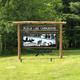 Entrance sign for “Pelican Lake Campground” on grassy frontage — clear identifying shot of the property entrance and branding.