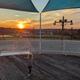 Wide deck/view at sunset with shade sails and park grounds visible — good overview of an elevated amenity and surrounding landscape.
