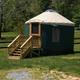 Exterior photo of a beige-topped yurt with deck and grassy site (Dreamcatcher Yurt) — clear accommodation shot consistent with the site's yurt inventory.