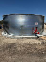 Close view of a large corrugated metal water tank located on-site — documents utilities/infrastructure important to the RV park.