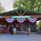 Photo of the campground office/pavilion storefront with visible Glacier Valley Campground sign and seating — useful for showing on-site facilities and check-in area.
