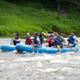 Group whitewater rafting on an inflatable raft branded with the property name — action shot showing recreational activities offered by the campground (homepage/camping page imagery).
