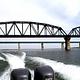 The wake behind a boat as it passes under the Highway 90 Bridge