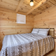 Interior bedroom of a wooden cabin with knotty pine walls — useful to illustrate cabin accommodation options (gallery page).