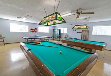 Interior recreation room with pool tables and ping-pong table — shows on-site clubhouse amenities listed on the resort page.