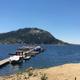 Wide lakeside view showing resort dock/piers, boats and distant tree-covered hills — clear photo from the main site homepage supporting this as the property marina/shoreline.