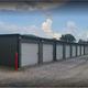 A row of storage units with blue doors filled with various items.