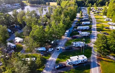 High-angle photo of RV sites along the lake with paved roads and pull‑through sites — useful for showing the campground’s RV area and proximity to the water (matches Amenities/RV Sites imagery).