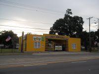 Street-facing photo of a distinctive yellow building (likely park office/entrance) on the property's site — helpful to identify the reception/road frontage and visitor entrance.
