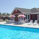 Clear photo of the main pool and poolside patio with clubhouse in background — illustrates on-site aquatic amenities (captioned on site as pools).